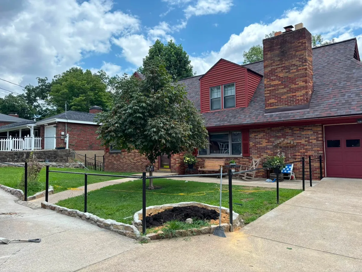 New black chain-link fence installed around a front yard