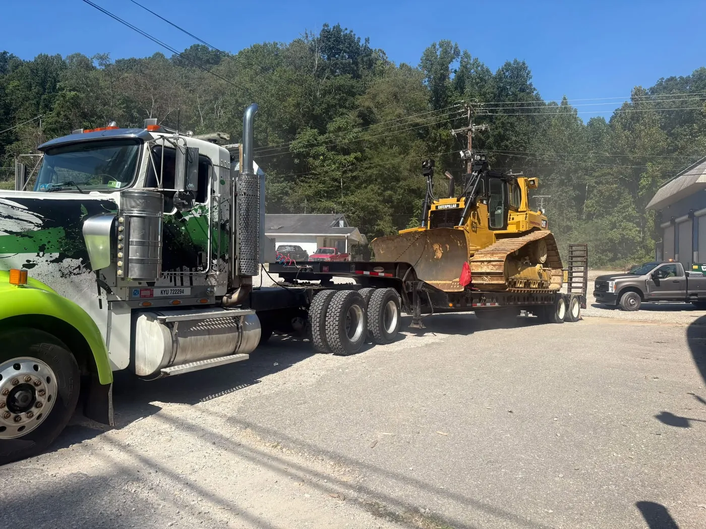 Mac Group truck hauling a bulldozer on a lowboy trailer