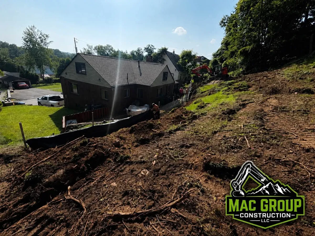 Graded hillside with silt fence behind a home