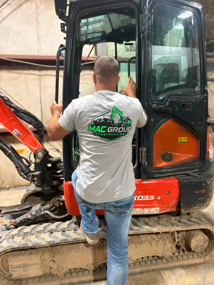Mac Group crew member climbing into a mini excavator