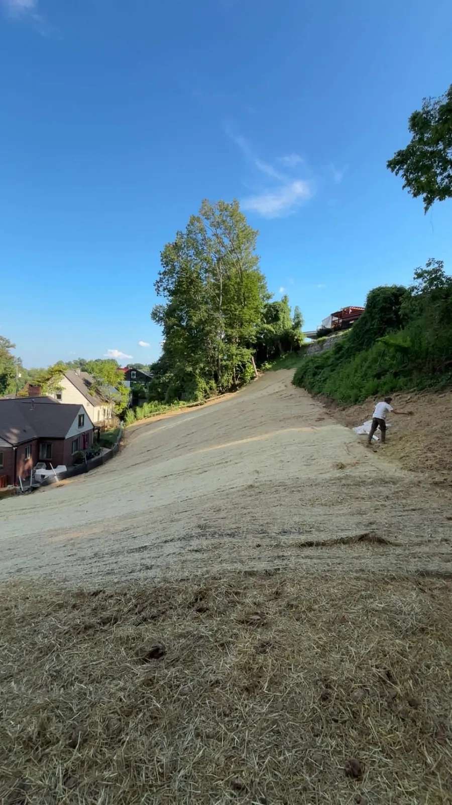 Freshly graded hillside with straw for erosion control